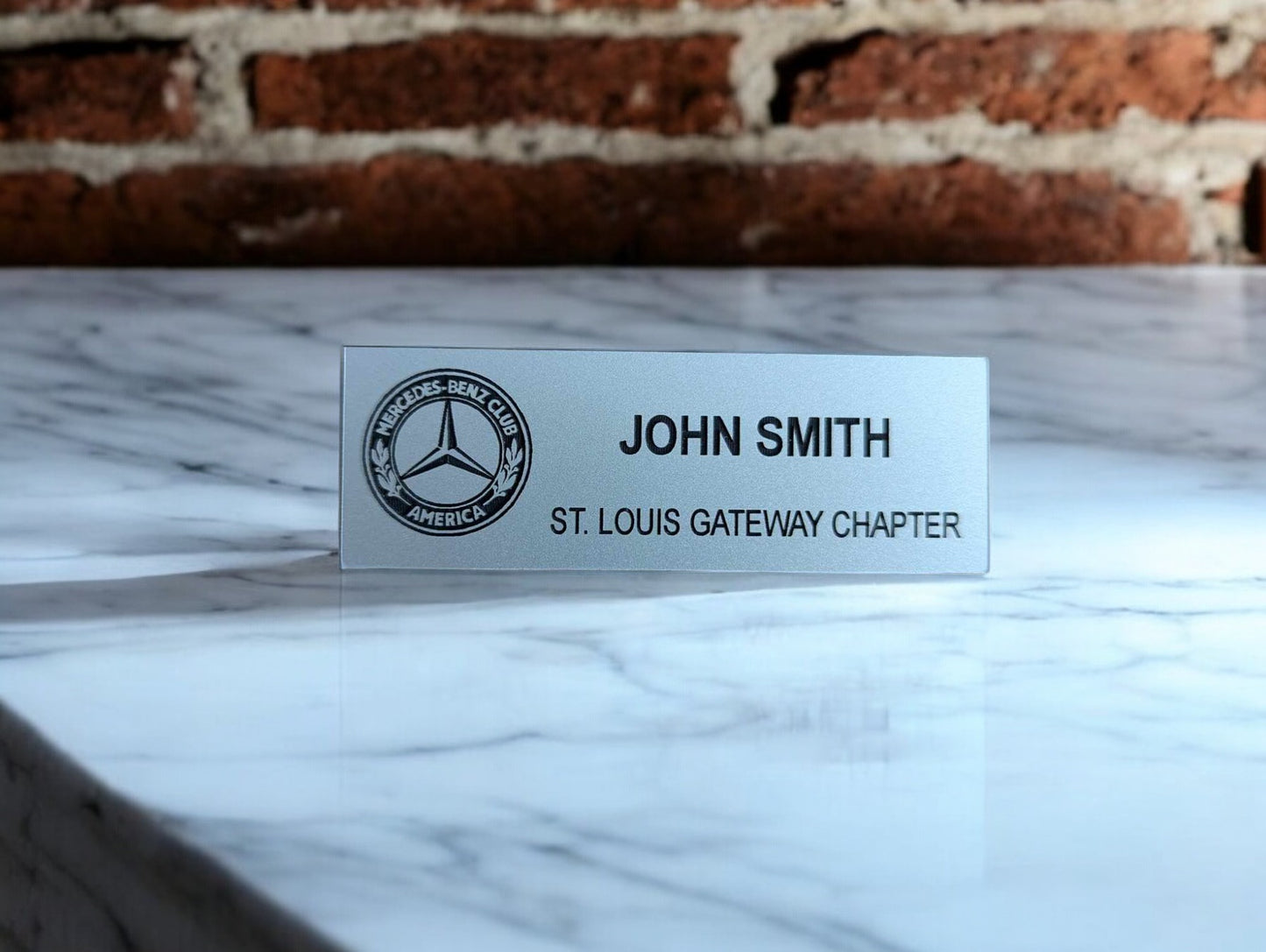 Silver name tag with black text and Mercedes Benz Club of America logo
